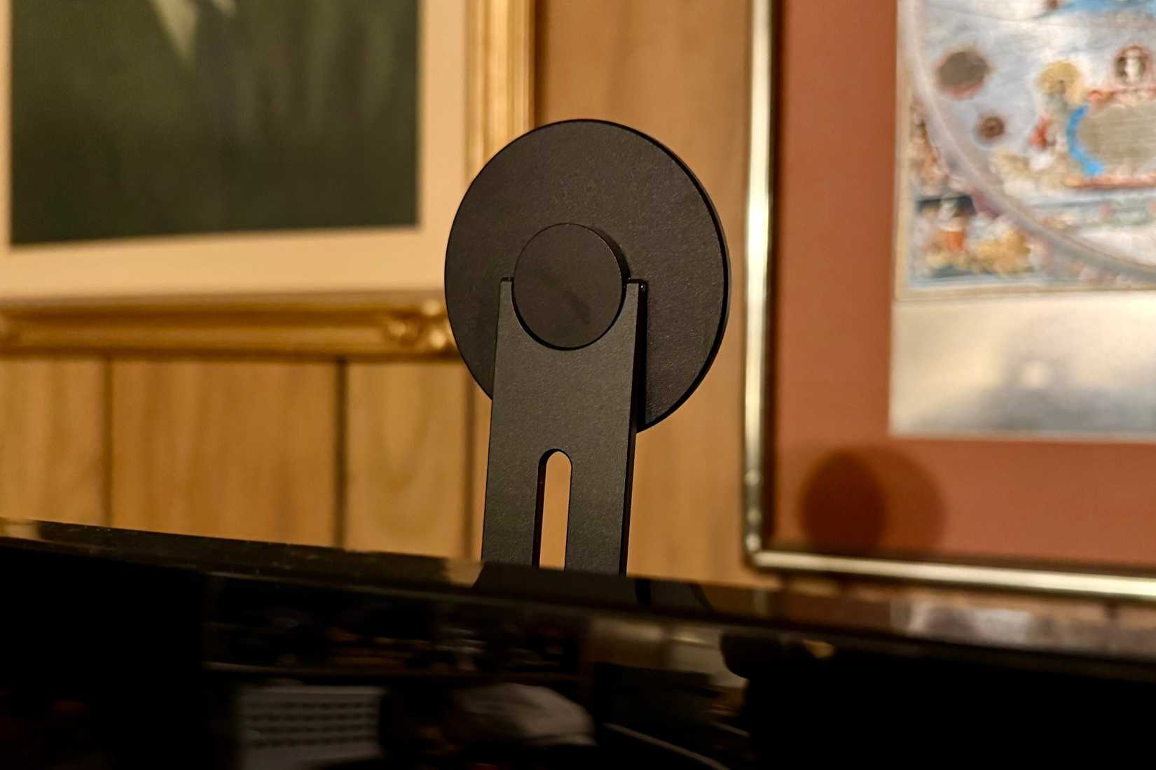 The MagSafe mount is adhesively attached to the back of a TV.