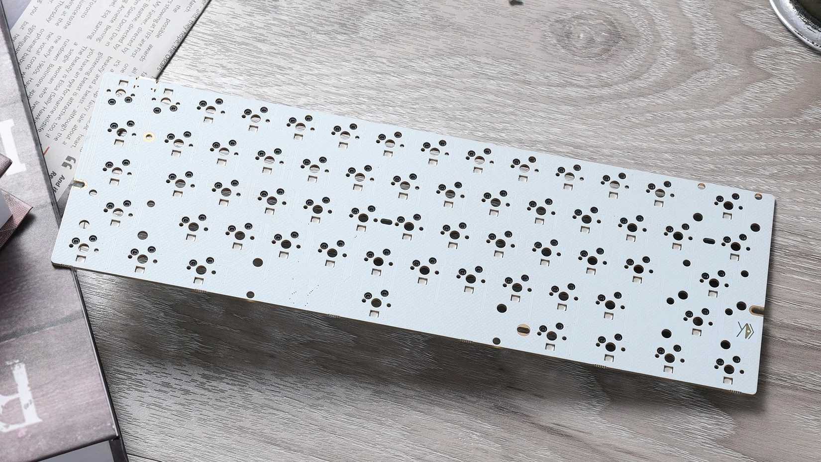 A KBDfans Redux 60 PCB lying on a table. 