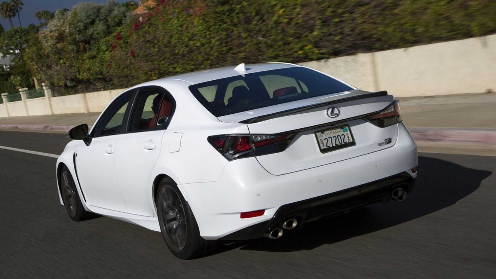 Toma dinámica de 3/4 de la parte trasera de un Lexus GS F 2016 blanco.