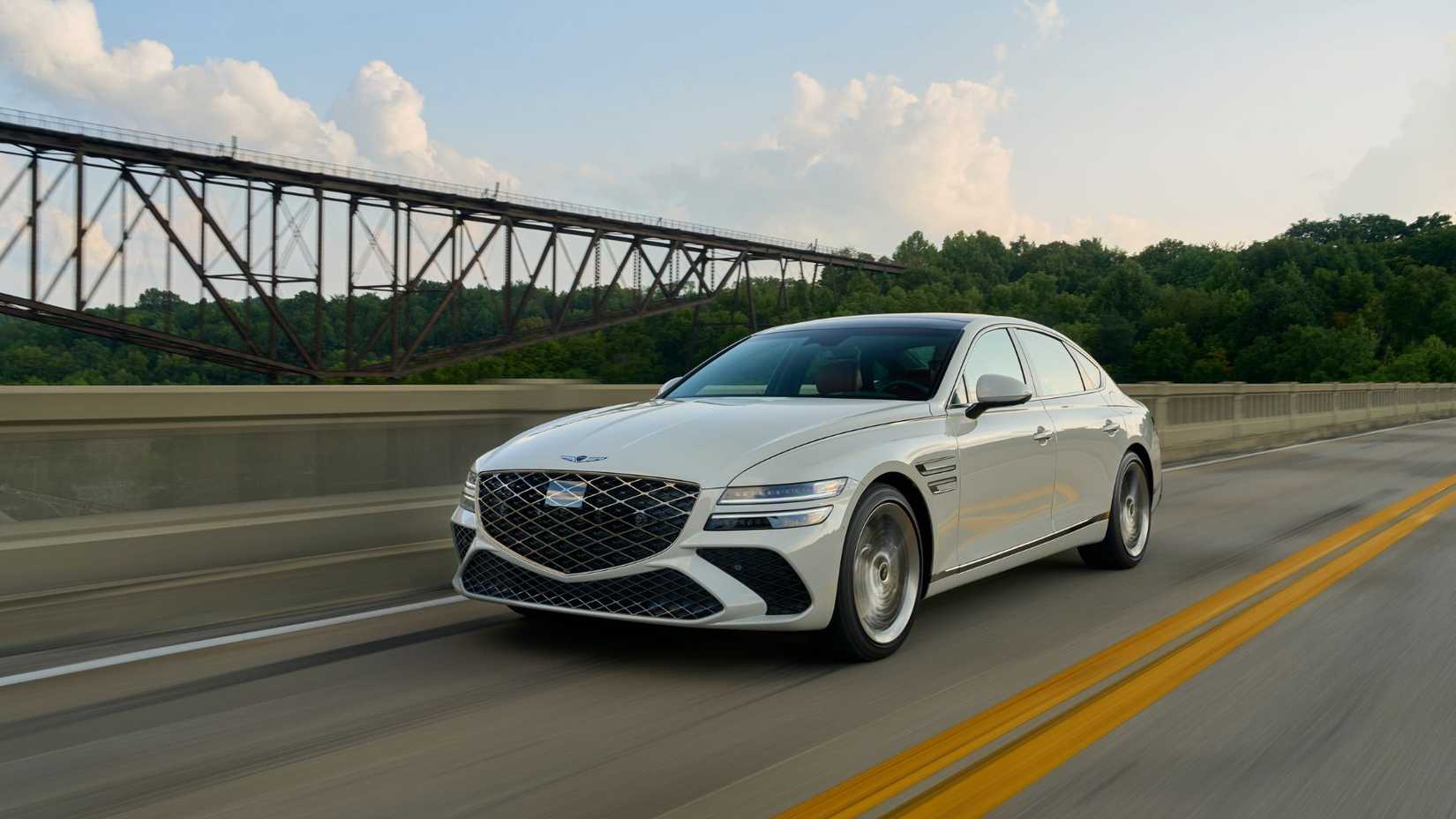 Dynamic front 3/4 shot of a 2025 Genesis G80 in white.