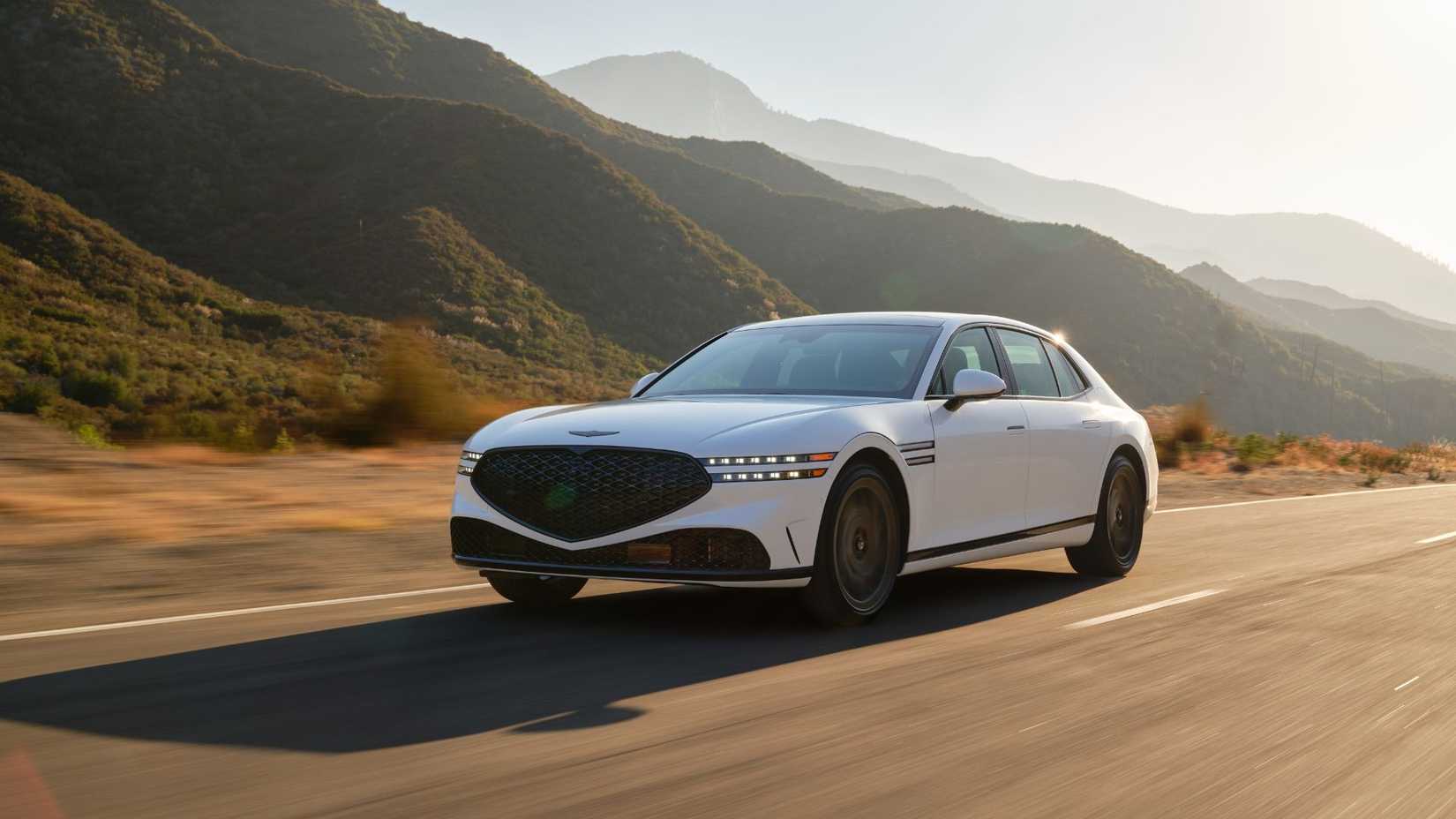 Dynamic front 3/4 shot of a white 2026 Genesis G90 Prestige Black.