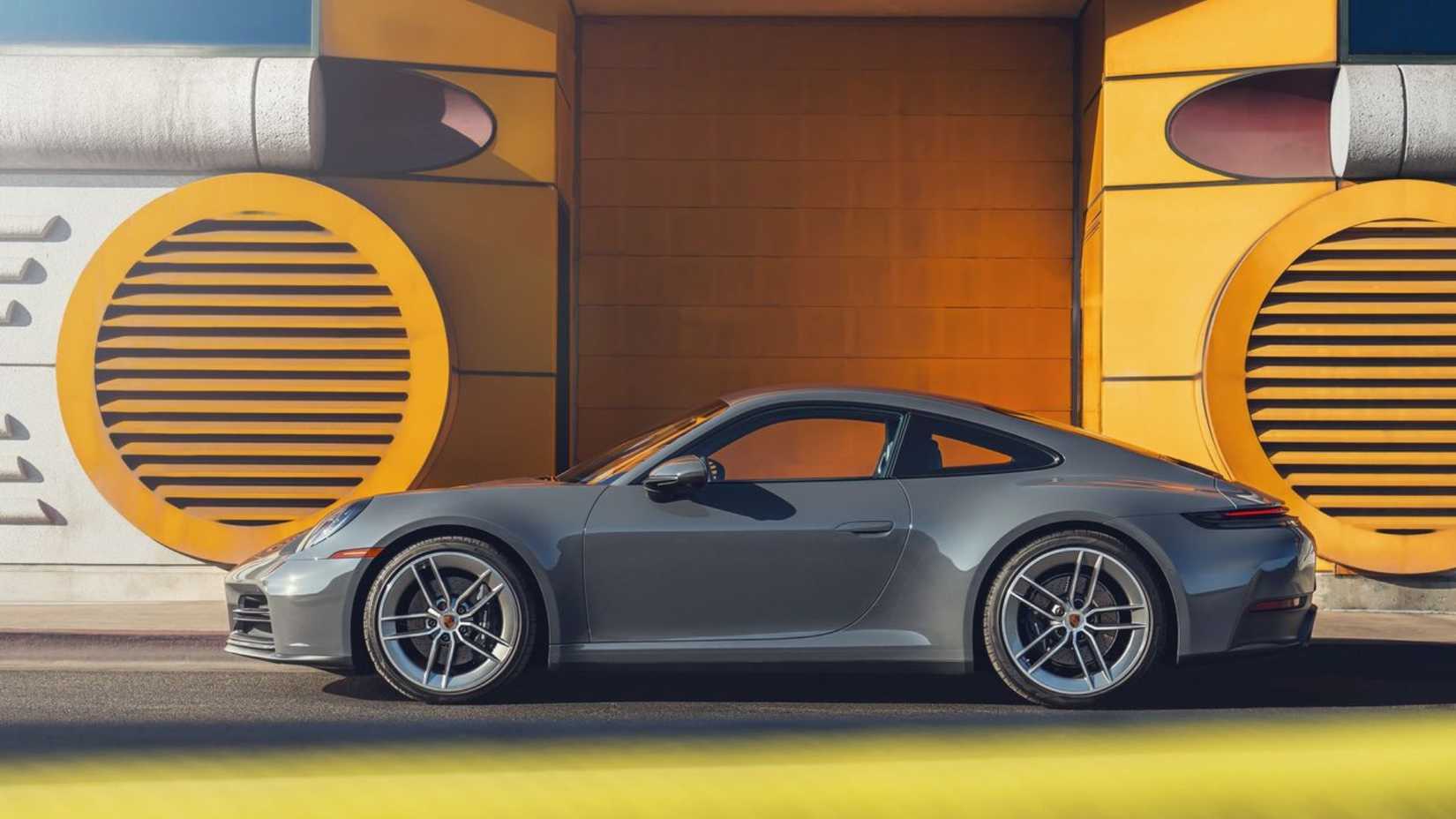 Static side profile shot of a gray 2025 Porsche 911 Carrera.