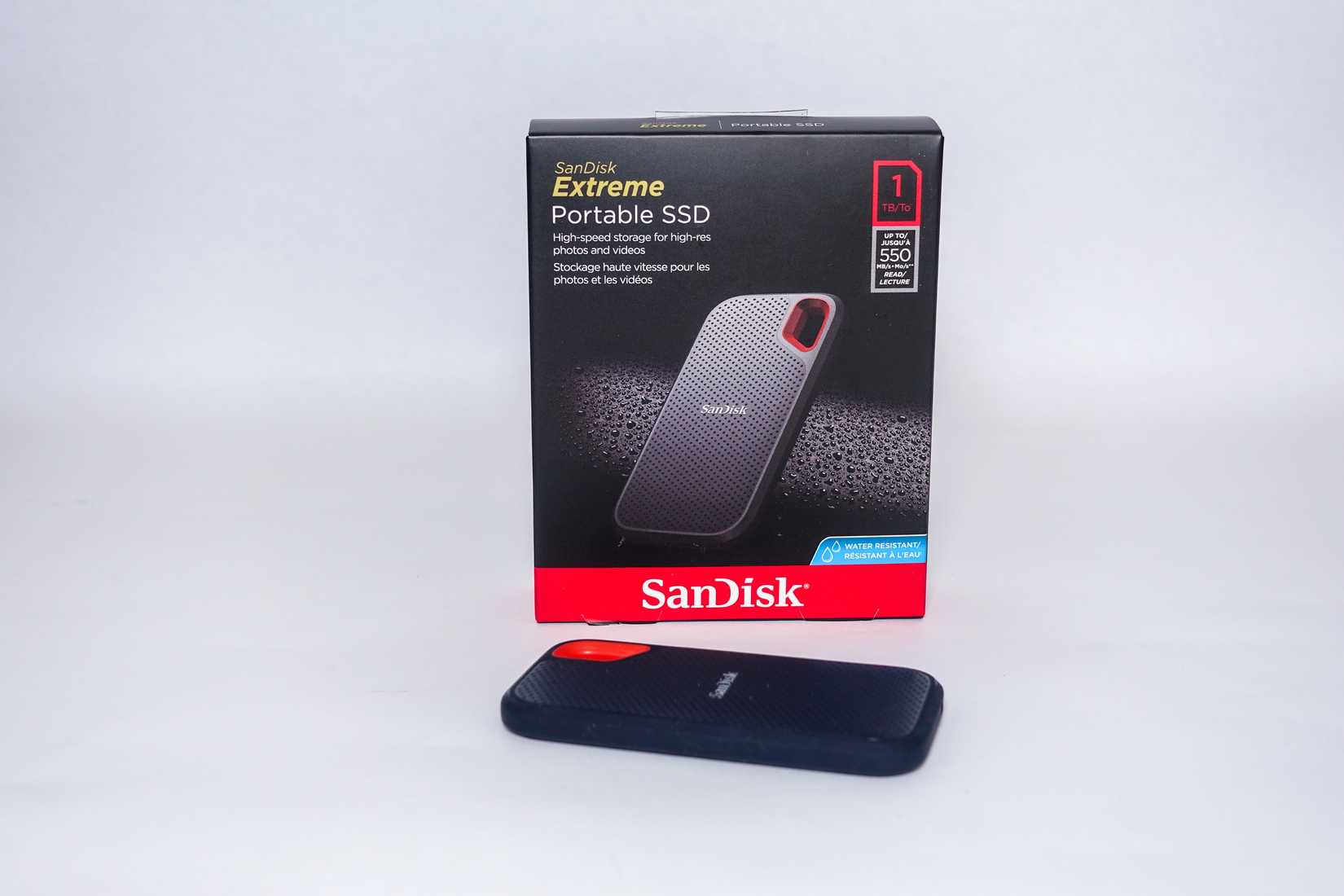 Um SSD portátil Sandisk Extreme próximo à sua caixa.