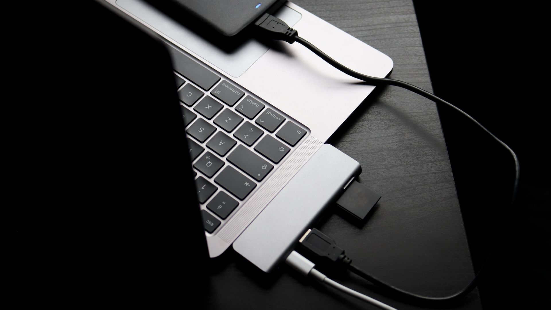 A laptop with an attached dock and several peripherals plugged in.