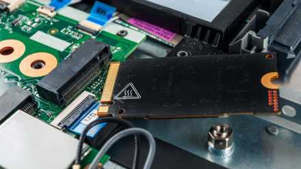 A laptop SSD with a heat warning label on the other side.