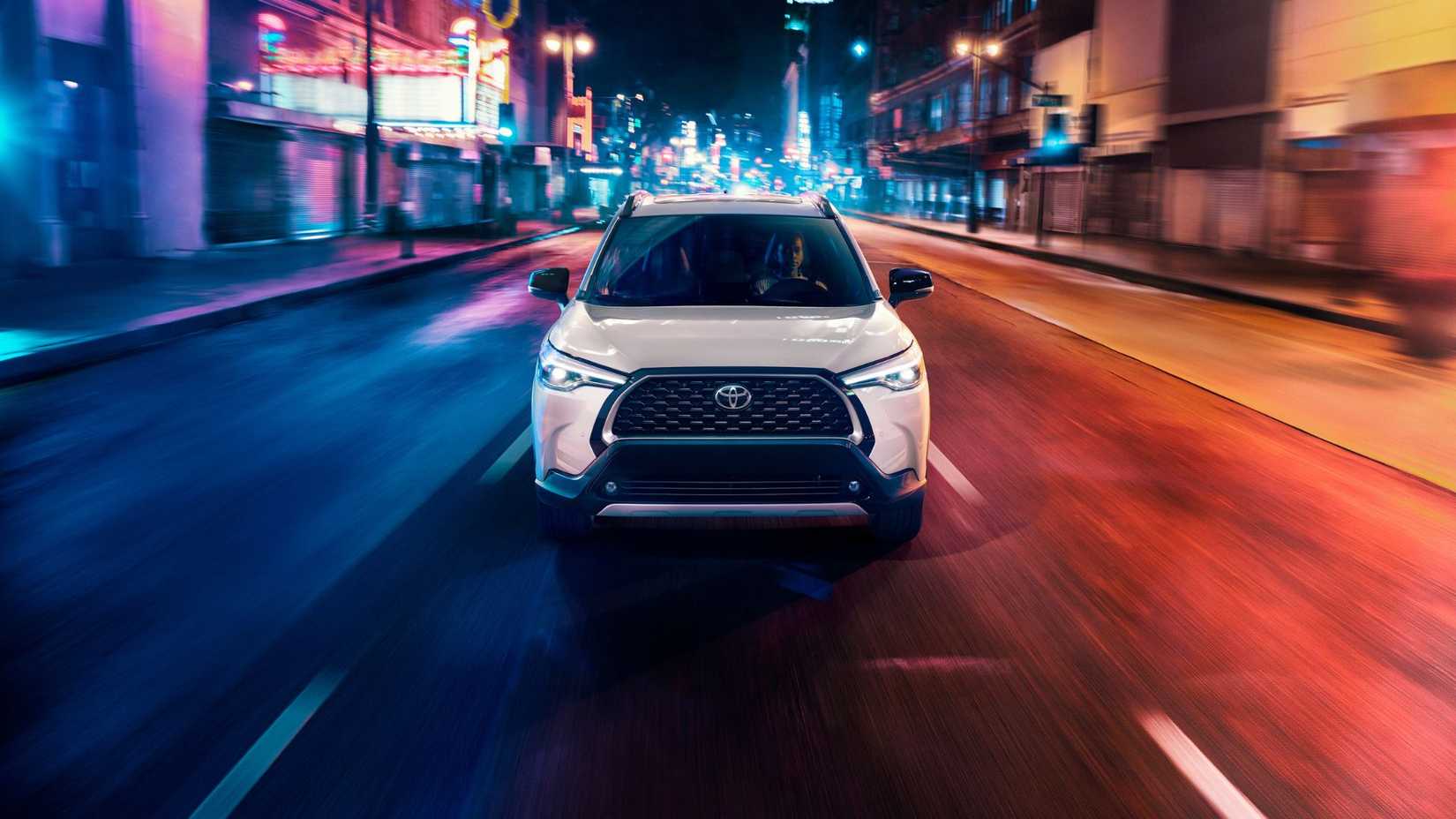 Dynamic front-end shot of a white 2025 Toyota Corolla Cross Hybrid XSE.