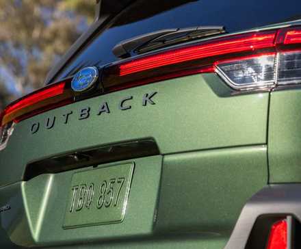 Close-up shot of the badging on the rear tailgate of a green 2026 Subaru Outback.