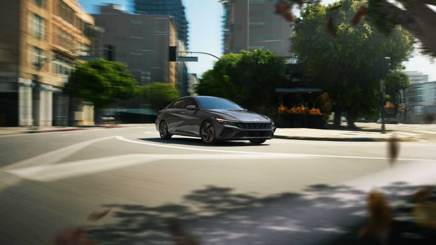 Dynamic front 3/4 shot of a gray 2026 Hyundai Elantra Hybrid.