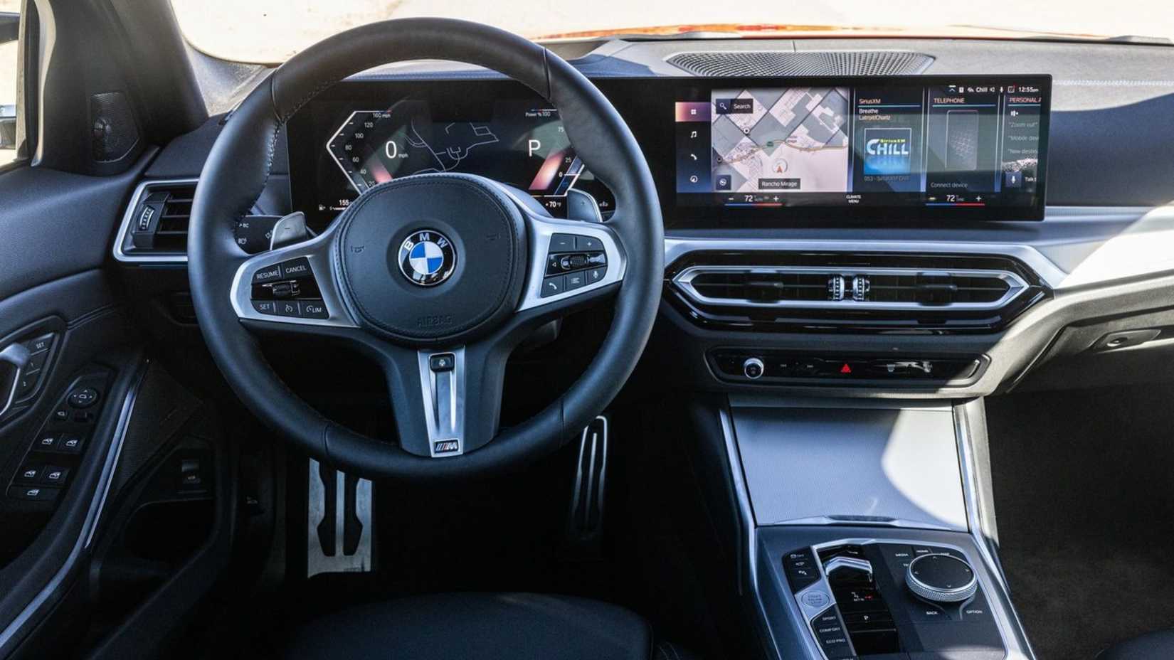 Close do volante e painel de controle dentro da cabine de um BMW M340i 2023.