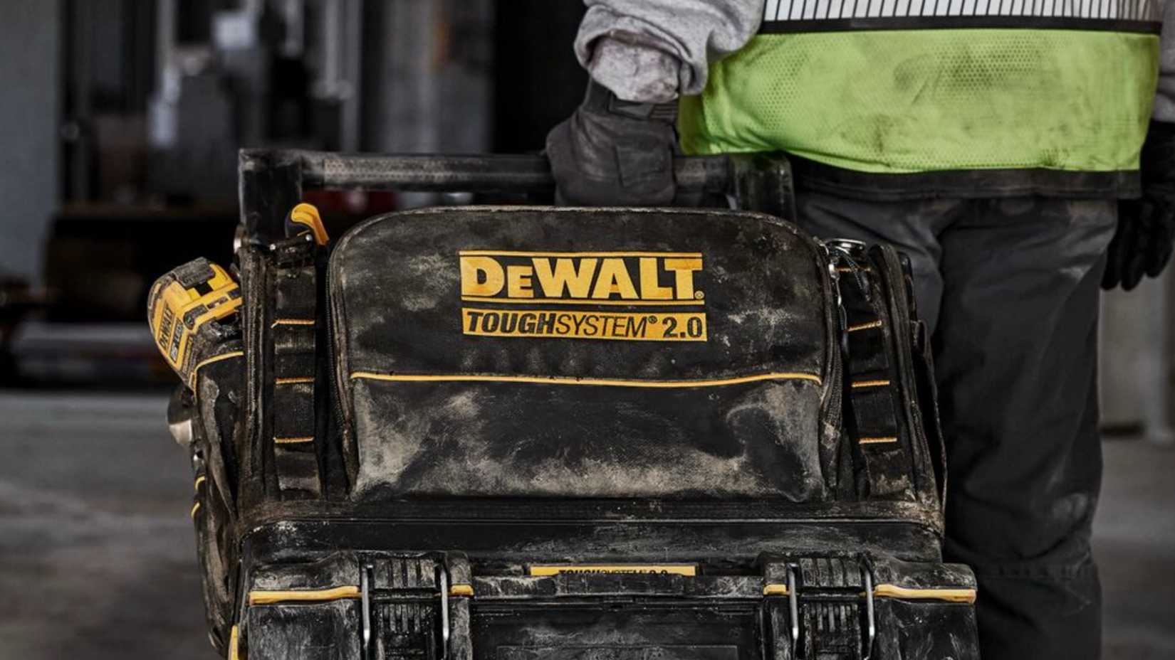 Человек достаёт ящик с инструментами DeWALT