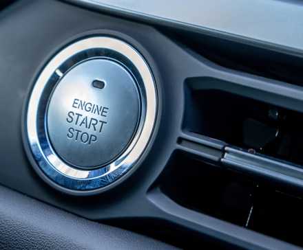 Engine start-stop button on the dashboard of a late-model vehicle.