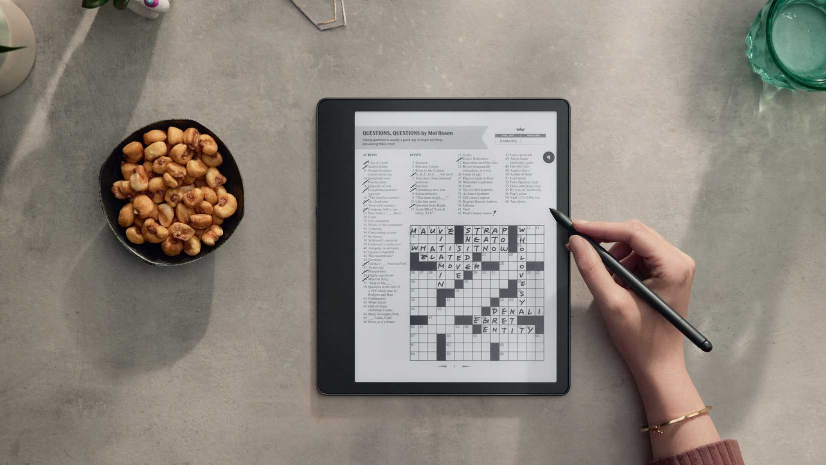 A person solving a crossword puzzle on a Kindle Scribe. 