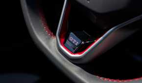 Close-up shot of the GTI badging on the steering wheel of a 2025 Volkswagen Golf GTI Autobahn.