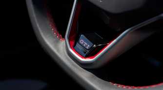Close-up shot of the GTI badging on the steering wheel of a 2025 Volkswagen Golf GTI Autobahn.