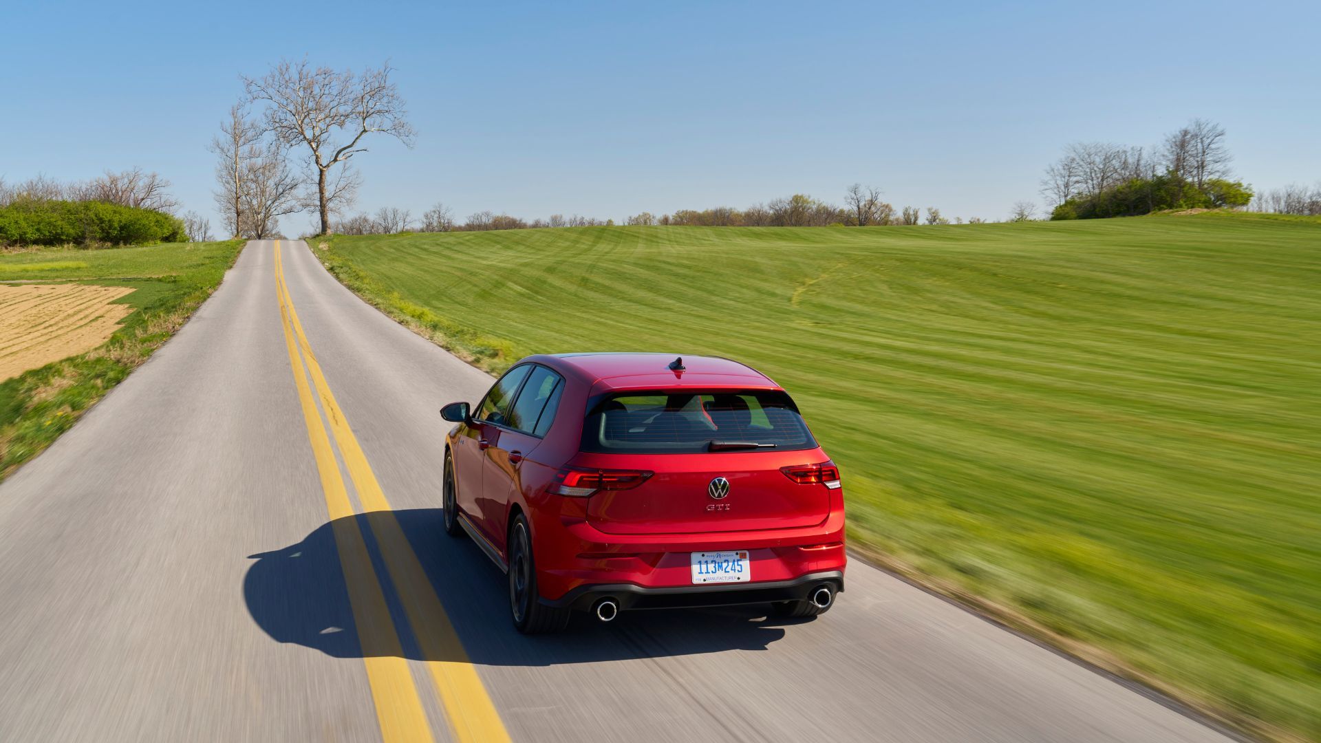 Dynamic rear-end shot of a red 2025 Volkswagen Golf GTI Autobahn.
