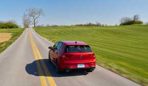 Dynamic rear-end shot of a red 2025 Volkswagen Golf GTI Autobahn.
