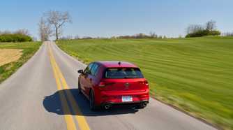 Dynamic rear-end shot of a red 2025 Volkswagen Golf GTI Autobahn.