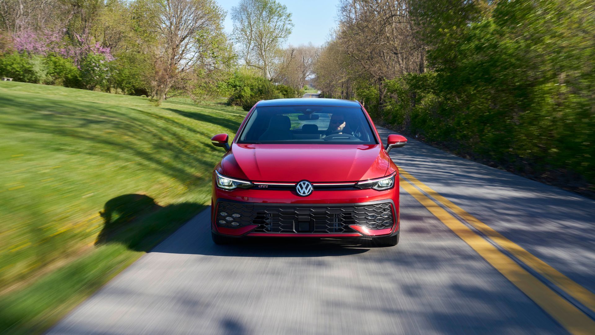 Dynamic front-end shot of a red 2025 Volkswagen Golf GTI Autobahn.
