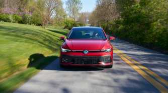 Dynamic front-end shot of a red 2025 Volkswagen Golf GTI Autobahn.