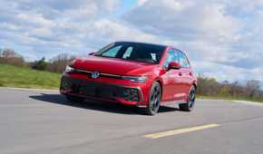 Dynamic front 3/4 shot of a red 2025 Volkswagen Golf GTI Autobahn.
