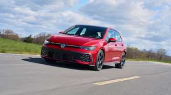 Dynamic front 3/4 shot of a red 2025 Volkswagen Golf GTI Autobahn.