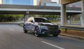 Dynamic front 3/4 shot of a gray 2026 Genesis GV70.