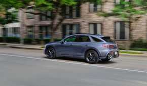 Dynamic rear 3/4 shot of a gray 2026 Genesis GV70.