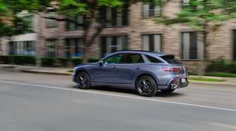 Dynamic rear 3/4 shot of a gray 2026 Genesis GV70.