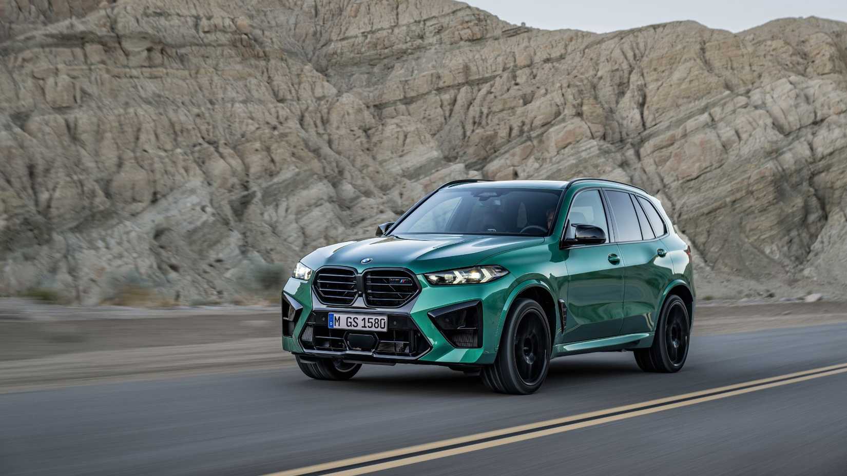 Dynamic front 3/4 shot of a green BMW X5 M Competition.