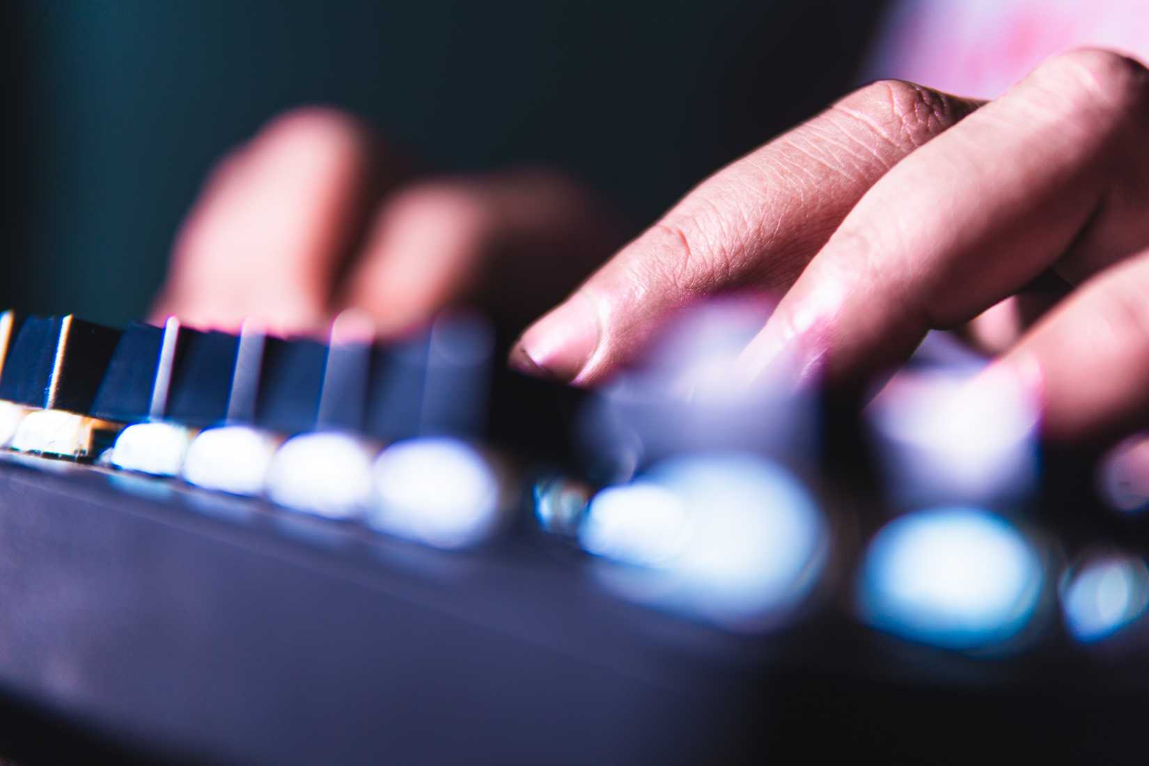 A close-up of fingers typing on a mechanical keyboard with glowing backlight.