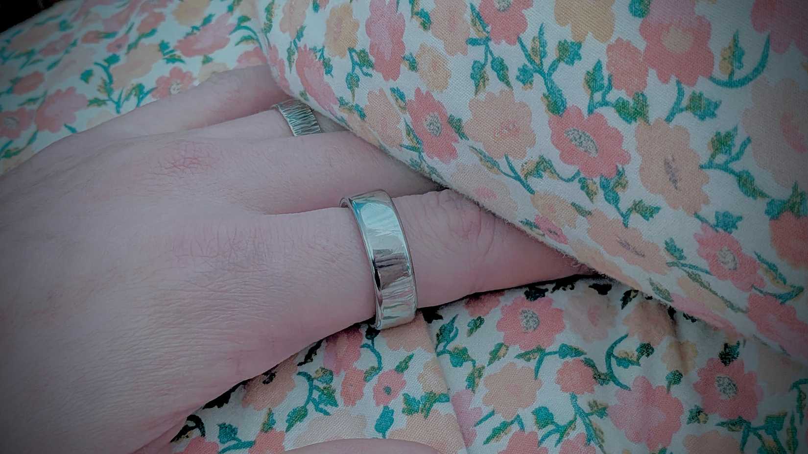 Oura Ring 4 on a hand in bed.