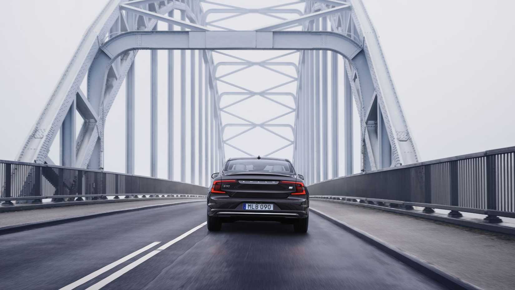 Dynamic rear-end shot of a gray Volvo S90 Recharge T8.