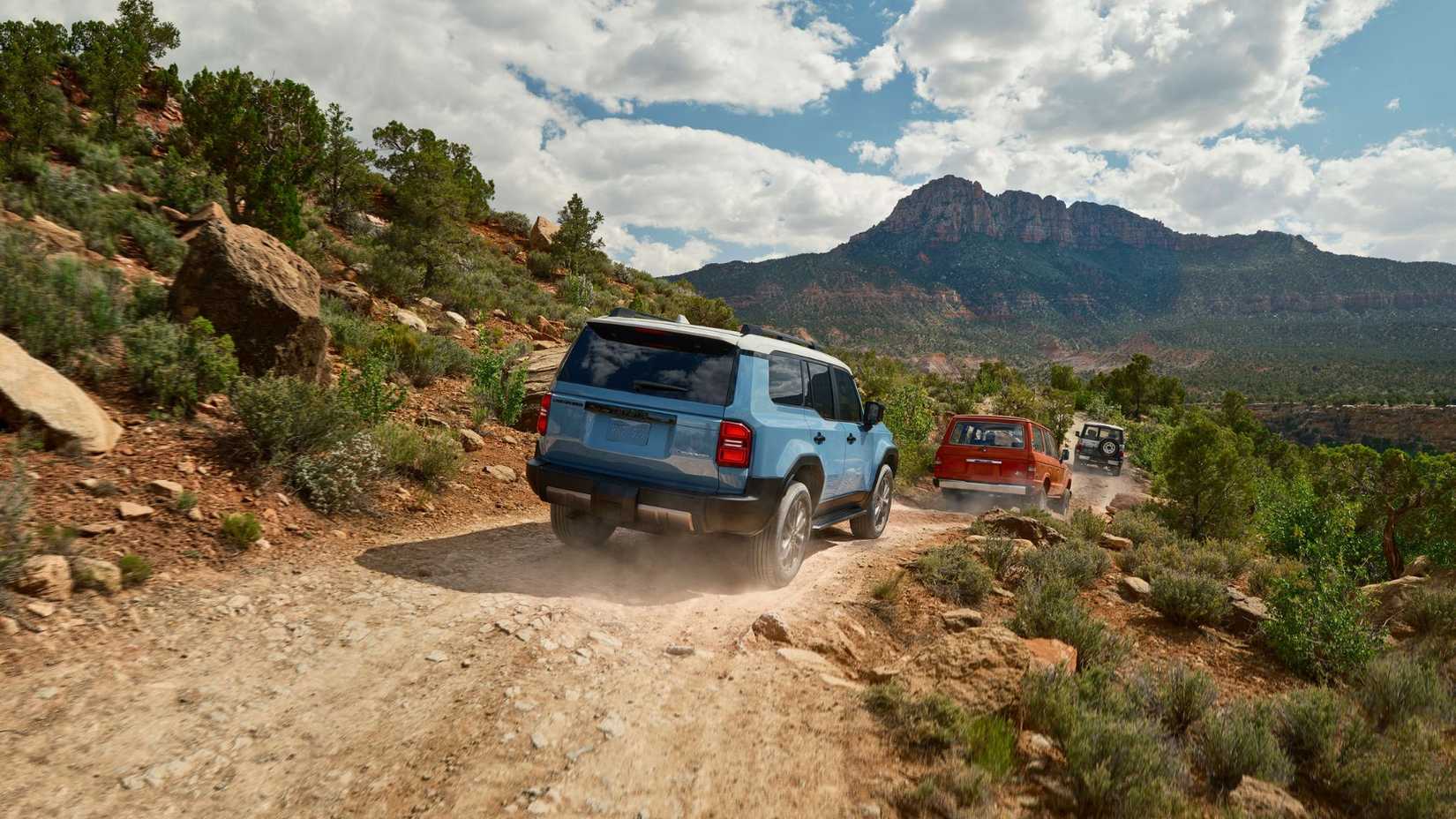 Dynamic rear 3/4 shot of a blue 2025 Toyota Land Cruiser.