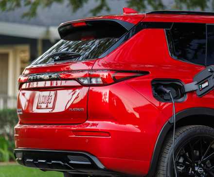 Красная Nissan Rogue Plug-in Hybrid 2026 с кабелем для зарядки