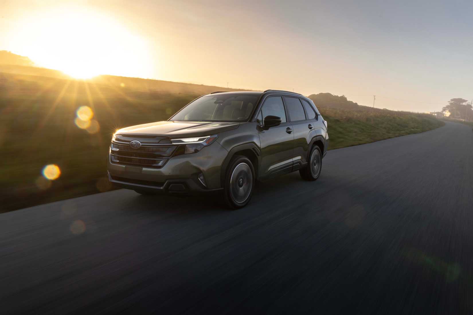 2026 Subaru Forester Hybrid driving on an open and scenic road. 