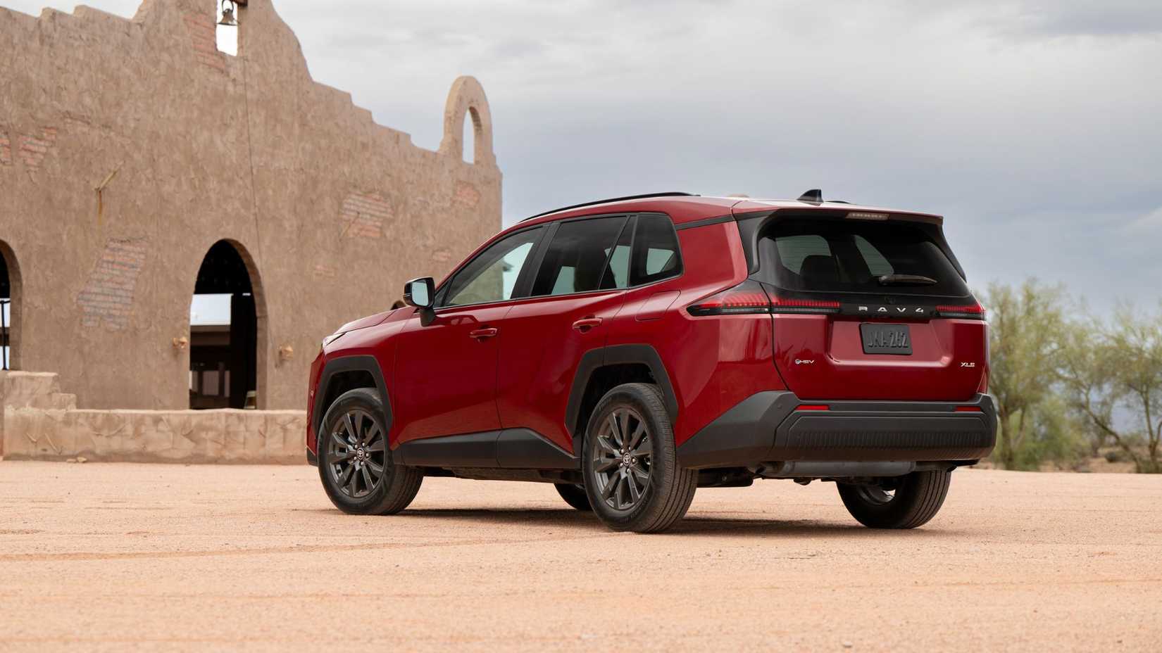 Plan 3/4 arrière statique d'un Toyota RAV4 HEV XLE Premium 2026 rouge.