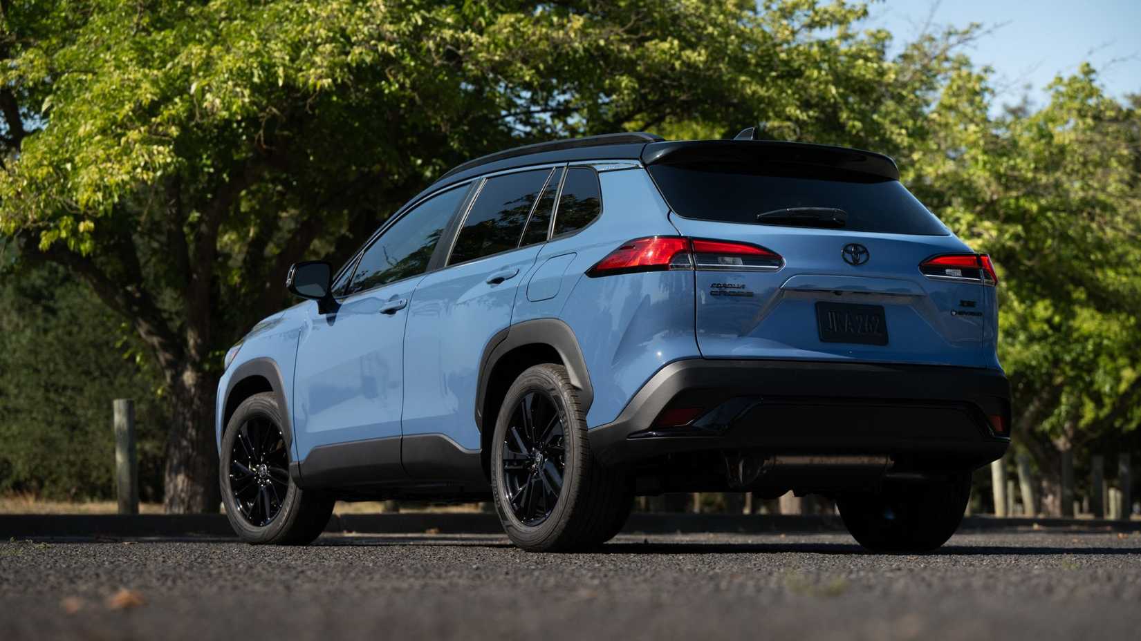 Static rear 3/4 shot of a blue 2026 Toyota Corolla Cross Hybrid XSE AWD.