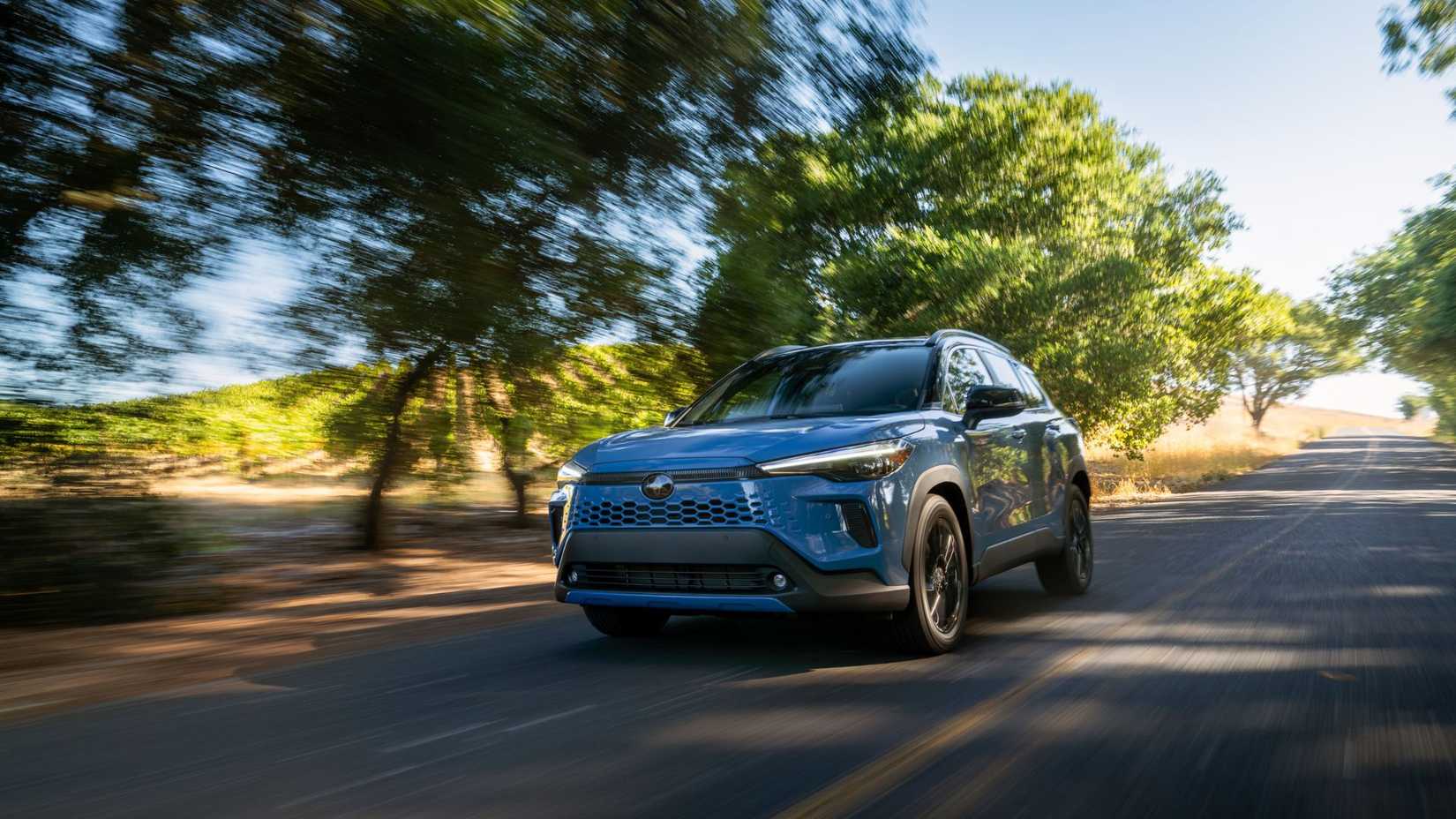 Dynamic front 3/4 shot of a blue 2026 Toyota Corolla Cross Hybrid XSE AWD.