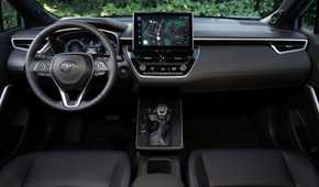 Shot inside the cabin of a 2026 Toyota Corolla Cross Hybrid XSE AWD, showing the front seats and dashboard.