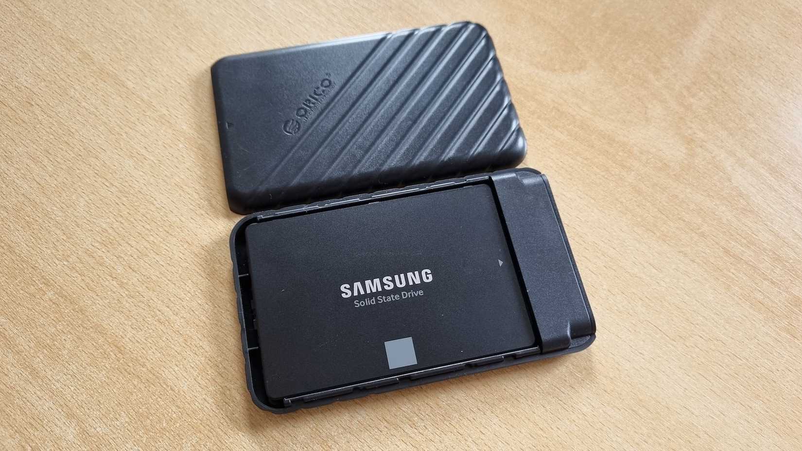 A an opened DIY external SSD showing a Samsung 850 EVO SATA SSD inside it lying on a table. 