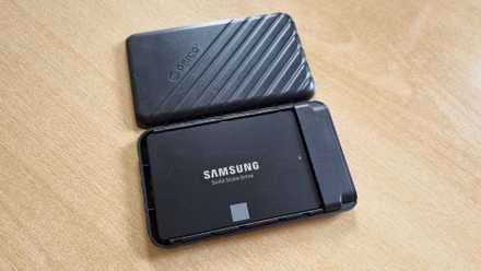 A an opened DIY external SSD showing a Samsung 850 EVO SATA SSD inside it lying on a table.
