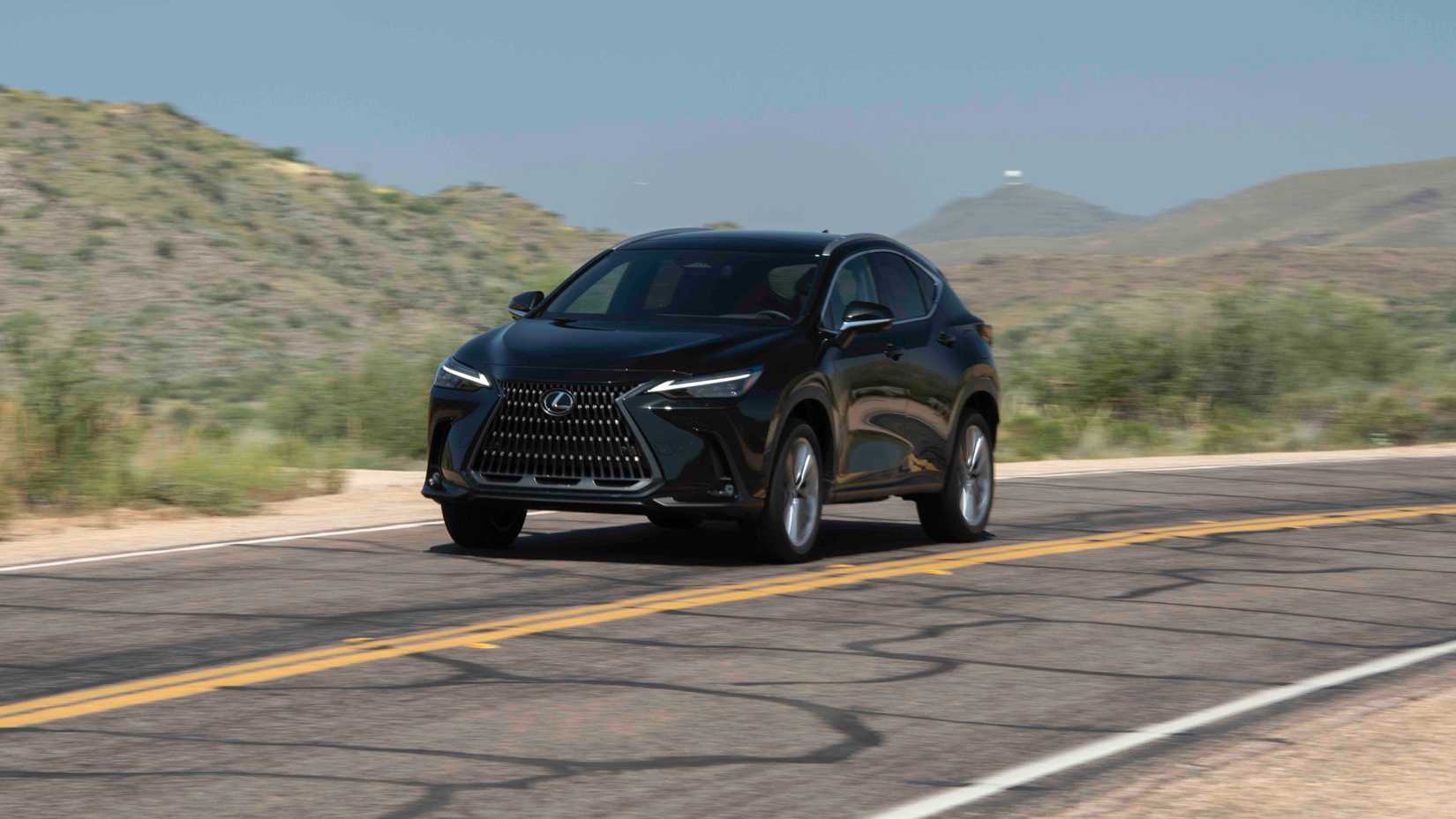 Black 2026 Lexus NX driving on the highway in a scenic area.