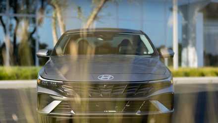 A gray 2026 Hyundai Elantra is parked in front of an office building