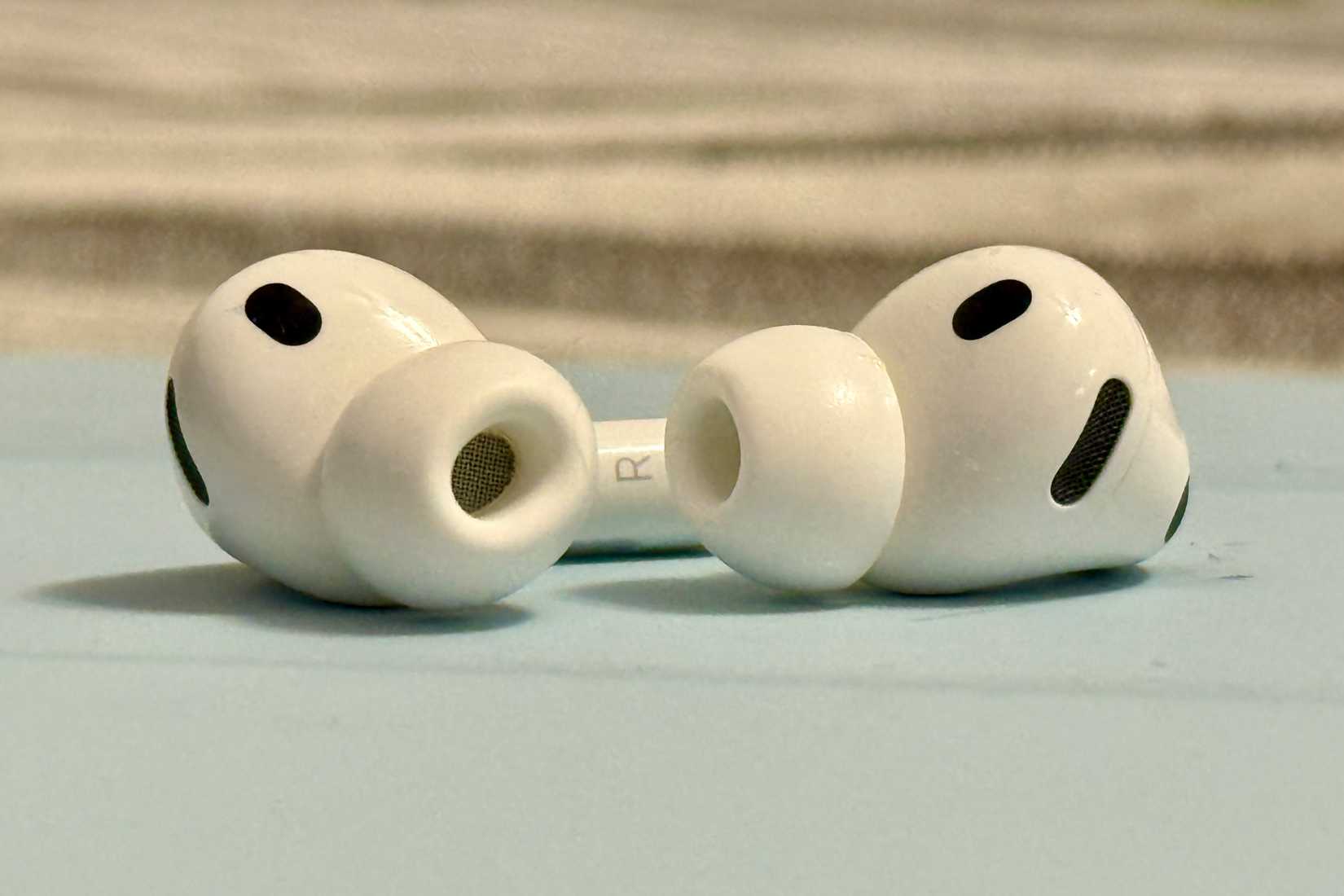 AirPods Pro 3 out of case, sitting on top of an iPad case.