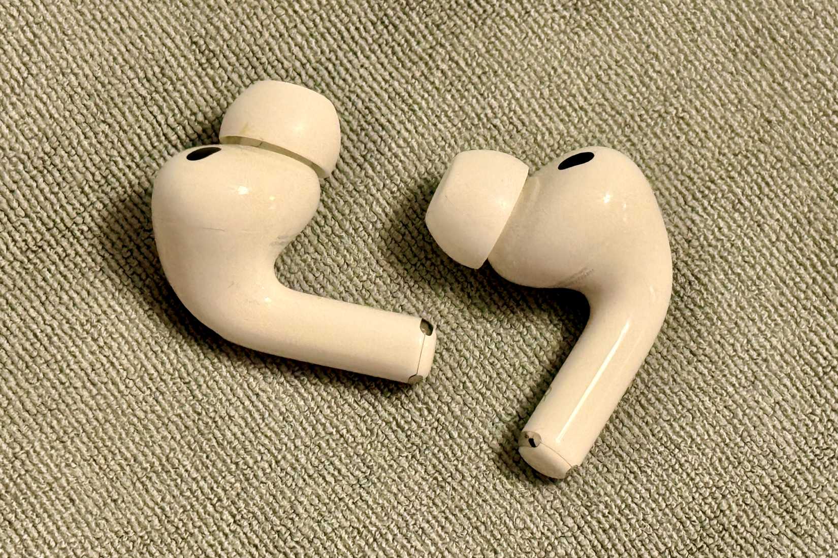 AirPods Pro 3 on a grey microfiber cloth.