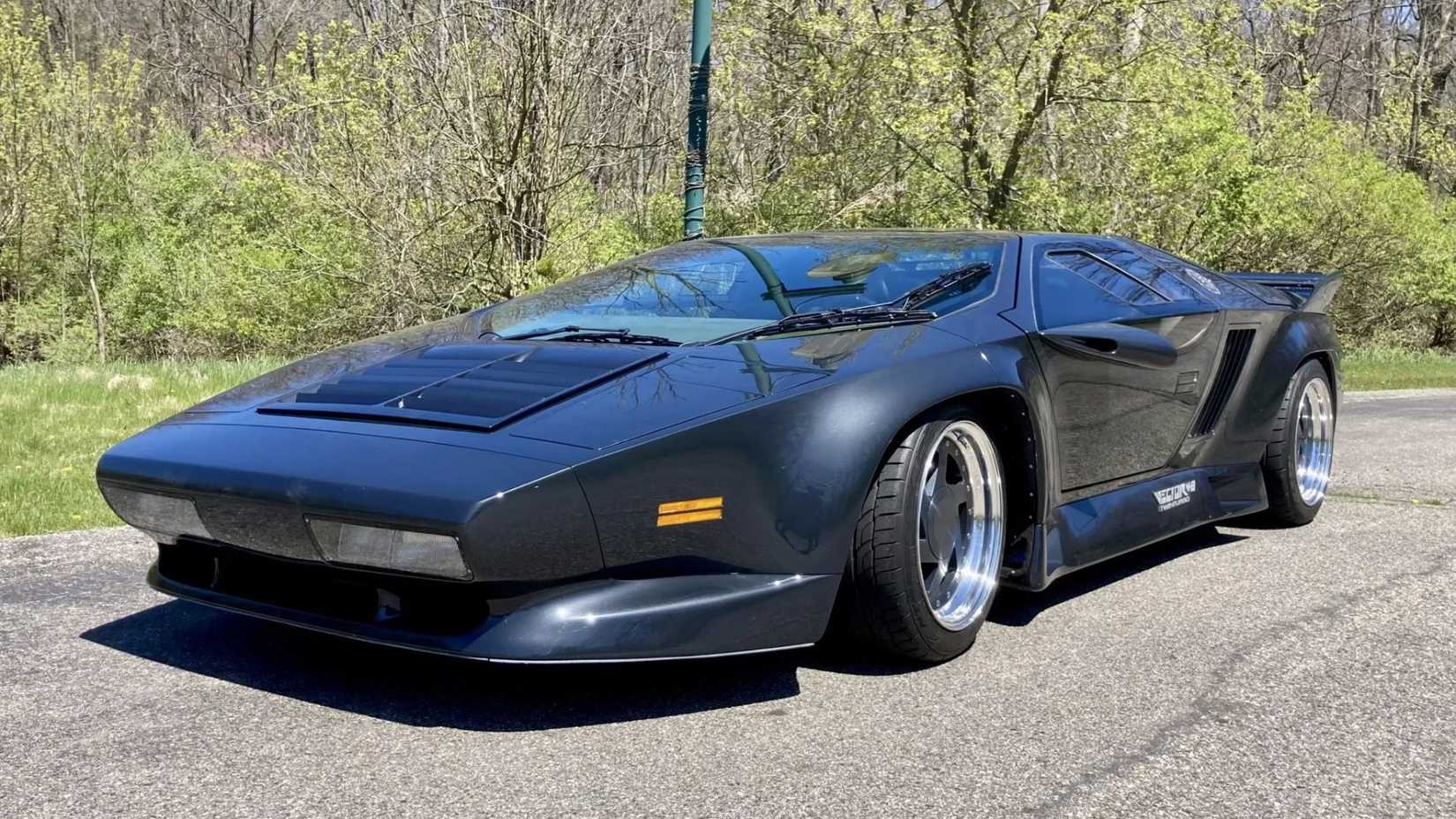 Toma estática frontal de 3/4 de un Vector W8 gris de 1990.