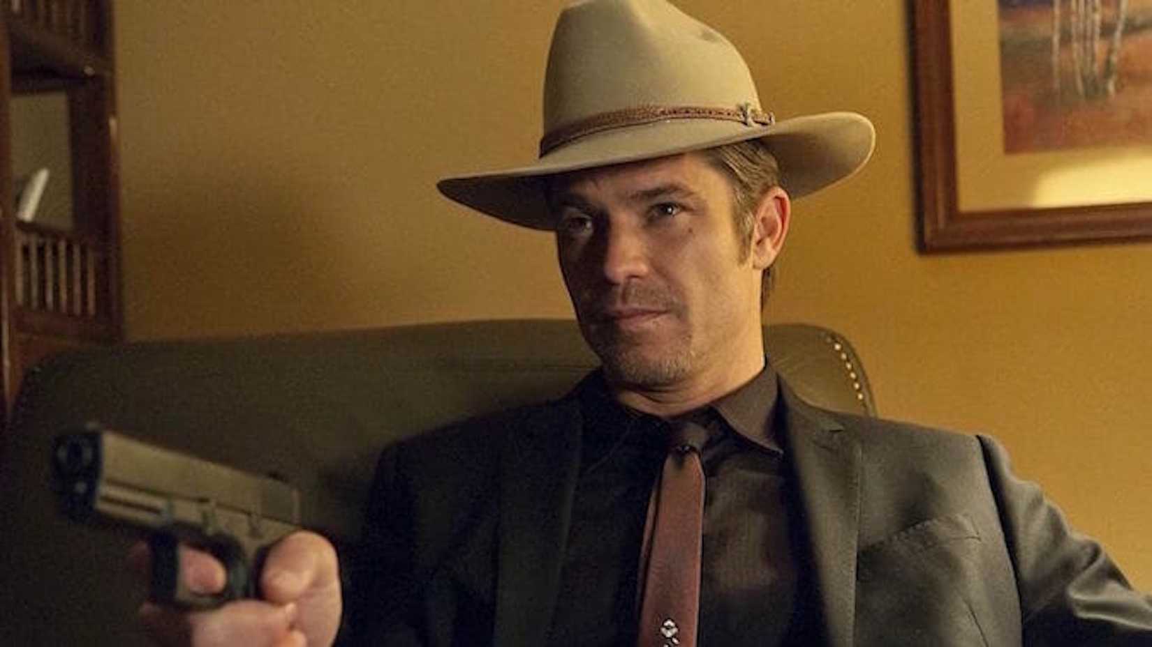 Timothy Olyphant como Raylan Givens, apuntando con un arma a la cámara, en Justified.