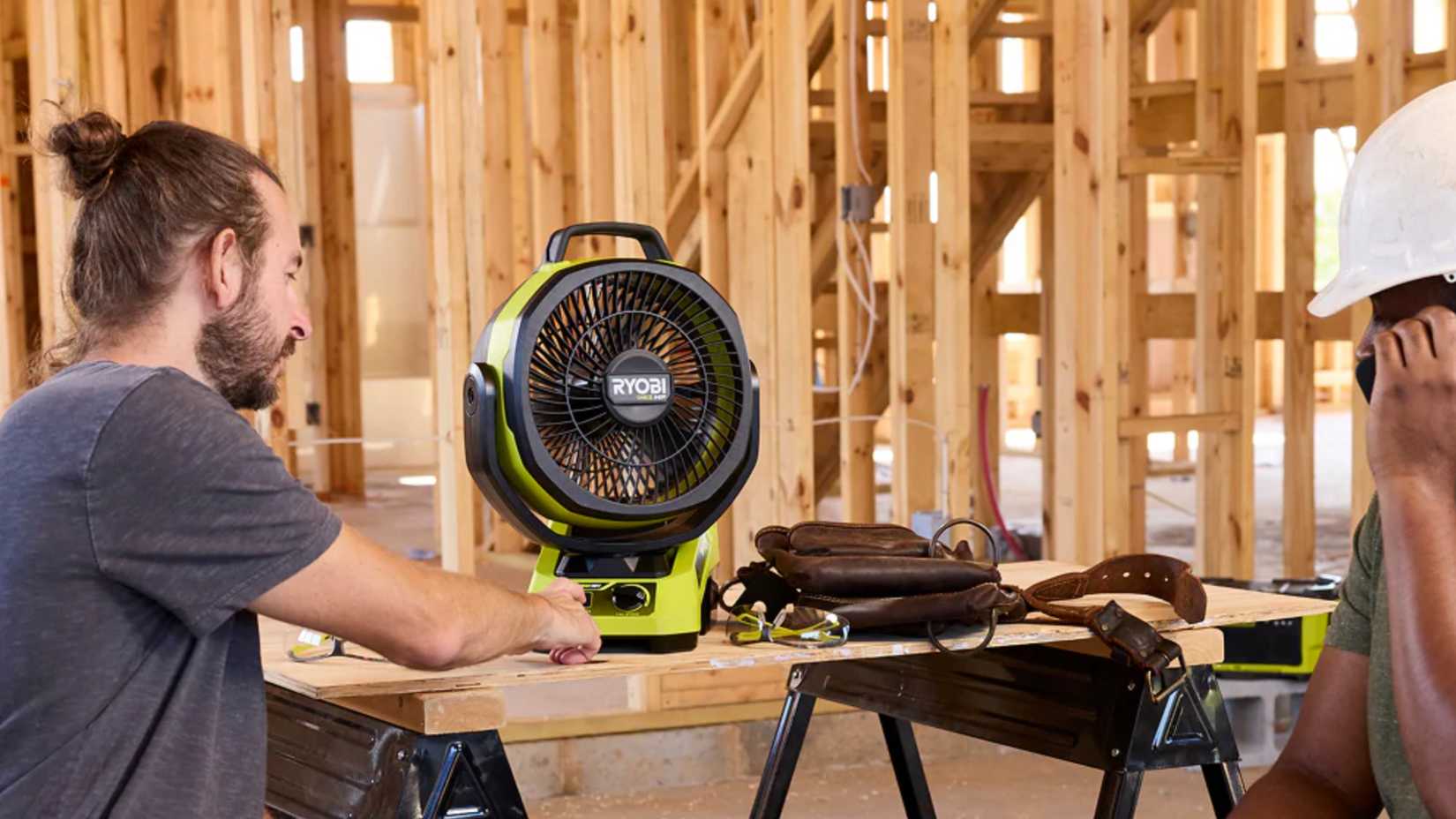 man turning on Ryobi's hybrid fan
