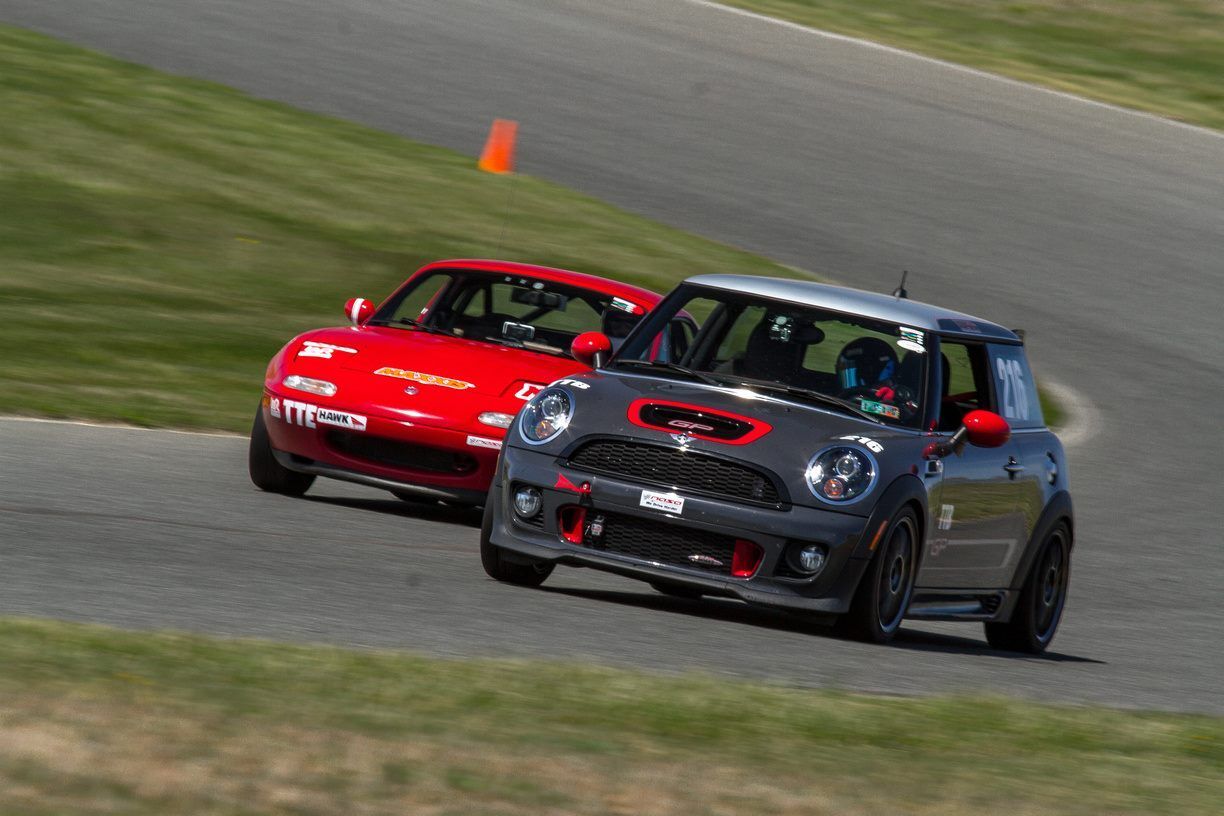 Mini Cooper and a Mazda Miata on a racetrack
