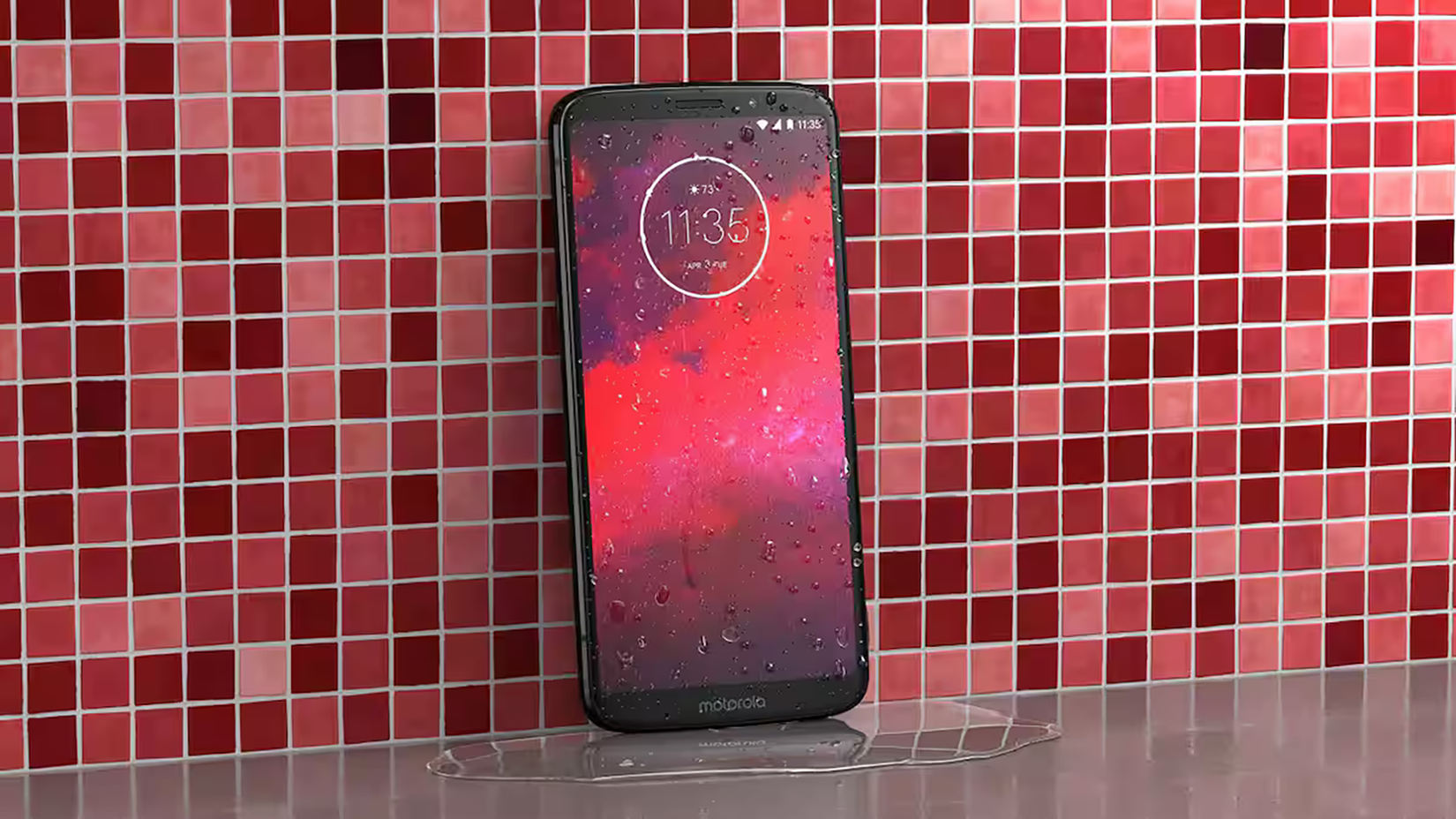 A Motorola Moto Z3 resting against a tile wall. 